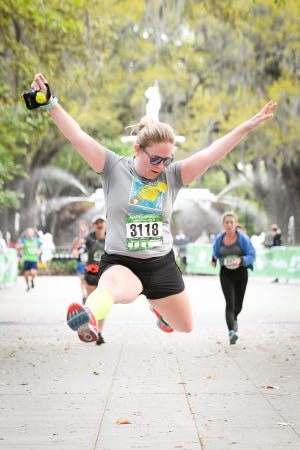 A runner leaps for joy at the finish line of the 2018 Savannah Women's Half Marathon. [Photo courtesy of Visit Savannah]