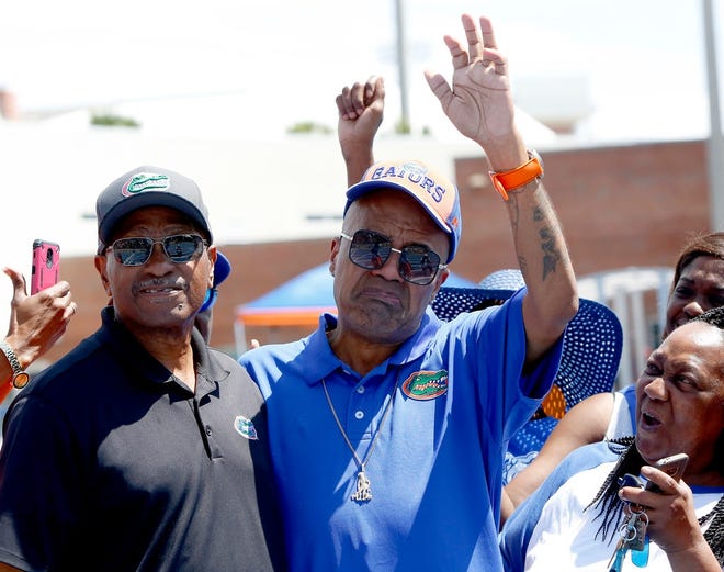 Legendary track and field star Tyrone Kemp, right, who was a decorated UF runner, Olympic medalist and native of Duval Heights in northeast Gainesville, waves and holds back tears after being presented an award by UF head coach Mike Holloway during the 2019 Pepsi Florida Relays held at James G. Pressley Stadium in Gainesville Saturday. The 400m race will be known as the Tyrone Kemp 400 at the Florida Relays. The annual track and field meet features athletes from both high schools and colleges from around the country. [PHOTO BY BRAD MCCLENNY/SPECIAL TO THE GUARDIAN]
