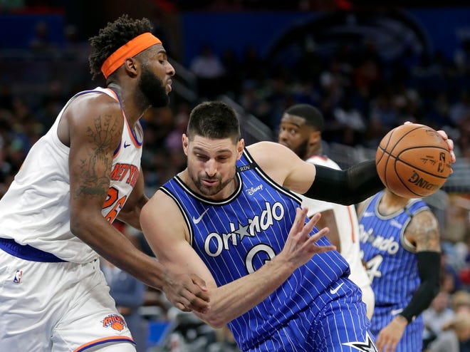 Orlando Magic's Nikola Vucevic, right, drives to the basket against New York Knicks' Mitchell Robinson during the second half of an NBA basketball game Wednesday, April 3, 2019, in Orlando, Fla. (AP Photo/John Raoux)