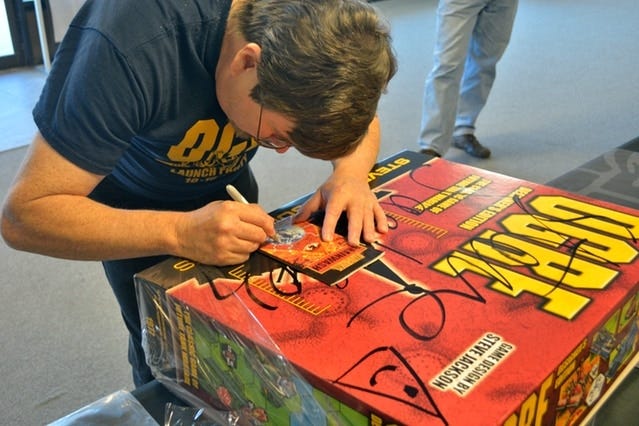 Steve Jackson signs a copy of the Ogre Designer's Edition in 2013. An online crowd-funding effort raised almost a million dollars for the project. [Contributed by Steve Jackson Games]