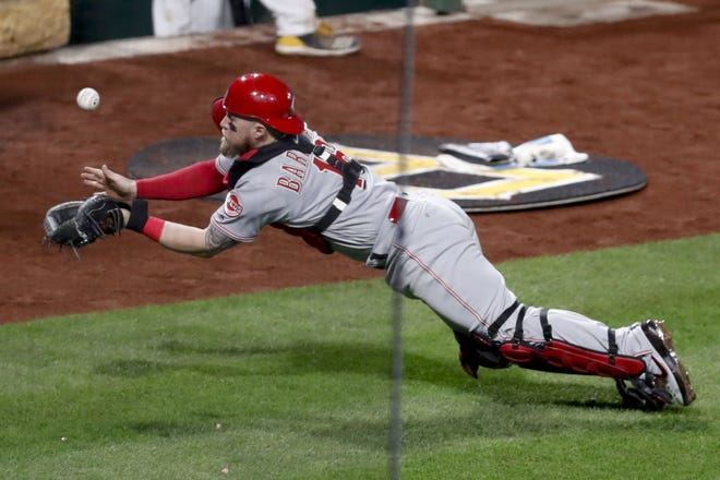 Cincinnati Reds catcher Tucker Barnhart dives while trying to catch a foul fly ball hit by Pittsburgh Pirates' Josh Bell during the sixth inning of a baseball game Thursday, April 4, 2019, in Pittsburgh. Barnhart did not make the catch. (AP Photo/Keith Srakocic)
