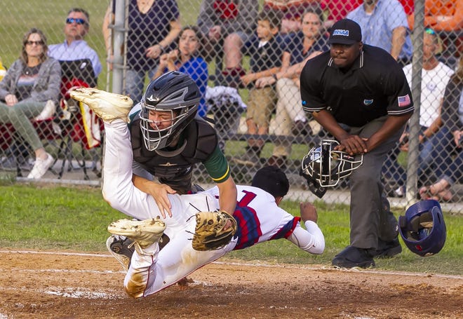 Forest's catcher (0) Tyler Thomas gets run over at home plate by Vanguard's Keyner Mejias (1) as he scores in the bottom of the first to make it 1-0. Vanguard defeated Forest 11-6 in seven innings Thursday night in Ocala. [Doug Engle/Staff photographer]