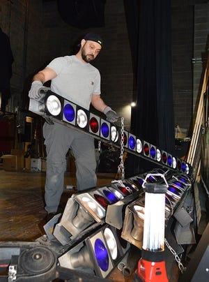 Marco DeSousa, Dagle Electrical Construction Corp., removes ‘70s era stage lights at New Bedford High School’s Bronspiegel Auditorium. The long-malfunctioning incandescent units are being replaced with a state-of-the art LED array, together with a topnotch acoustical system. (Submitted photo)