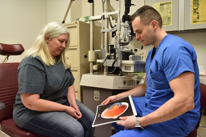 Dr. Anton Vlasov, WAMC Ophthalmology Clinic, explains to a patient what a cataract is and how cataract surgery could improve her vision.