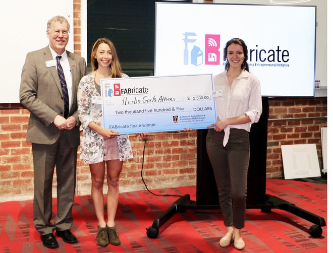 CAES Dean and Director Sam Pardue congratulates CAES agribusiness master’s degree student Eileen Schaffer and psychology student Amy Wright, otherwise known as Herb Girls Athens, for their win at the 2019 FABricate entrepreneurship competition. [Contributed]