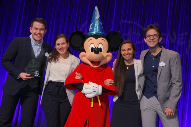 These SCAD students won Walt Disney Imagineering's 28th Imaginations Design Competition. Shown with Mickey Mouse, they are, from left, Ezekiel Waters, Carolyn Teves, Mickey Mouse, Remi Jeffrey-Coker and Nicholas Hammond. [©Disney/photo by Gary Krueger]