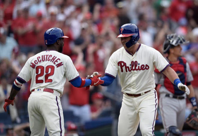 The Phillies' Rhys Hoskins, right, celebrates with Andrew McCutchen, left, after hitting a two-run home run off Minnesota Twins starting pitcher Jose Berrios Sunday. [MICHAEL PEREZ / THE ASSOCIATED PRESS]