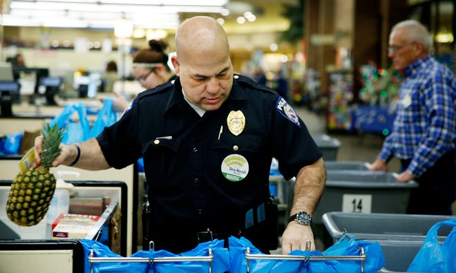 City of Ashland Police Chief Dave Marcelli helps bag groceries at Buehler's Fresh Foods in Ashland for the Celebrity Bagger Day on Saturday. Customers who donated to the Harvest for Hunger campaign had their groceries bagged by local celebrities at select Buehler’s locations. Mayor Matt Miller and Ashland Municipal Court Mediator Fred Oxley also were on hand to bag groceries and load them into customers' cars on Saturday.