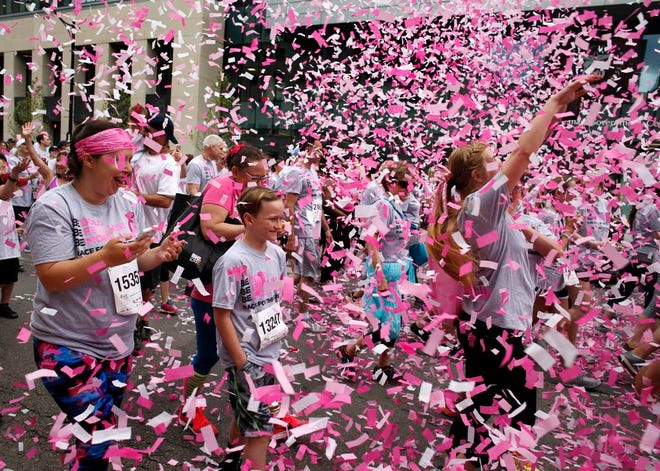 People walk through confetti at the 26th annual Komen Columbus Race for the Cure on Saturday, May 19, 2018.