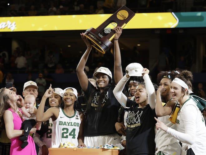 Baylor center Kalani Brown holds the championship trophy next to guard Chloe Jackson (24) after Baylor defeated Notre Dame 82-81 in the final of the NCAA women's college basketball tournament on Sunday in Tampa. [Chris O'Meara/AP]