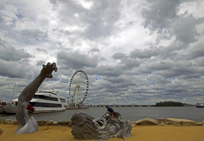 In this Sept. 3, 2016, file photo, children play on J. Seward Johnson's sculpture, "The Awakening," along the Potomac River waterfront at National Harbor, Md. Federal prosecutors say a man inspired by the Islamic State group stole a U-Haul truck with plans to drive it into a crowd at National Harbor, a convention and tourist destination just outside the nation's capital. [AP File Photo/Jose Luis Magana]