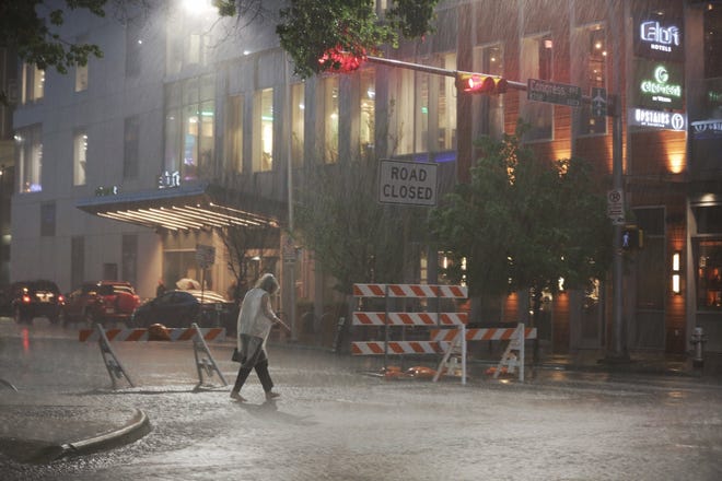 Heavy rain falls in downtown Austin on Sunday after the Statesman Capitol 10,000 race was canceled because of dangerous lightning. [BRONTE WITTPENN/AMERICAN-STATESMAN]