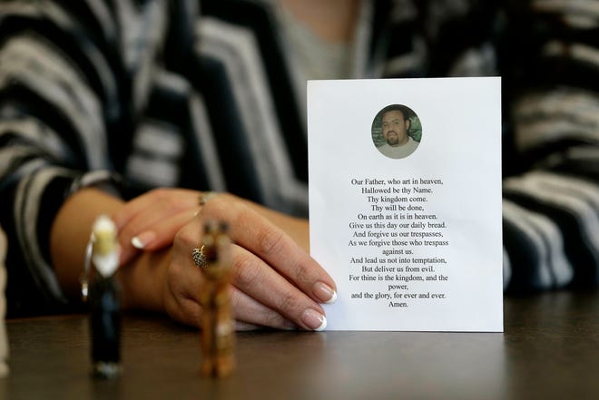 In this photo taken Wednesday, March 6, 2019 in Raleigh, N.C. Heather Allen holds a photo of her father, Lee Wayne Hunt, from his memorial. Even though Lee Wayne Hunt died as a prisoner found guilty of a double murder, his family says he never gave up hope of proving his innocence. (AP Photo/Gerry Broome)