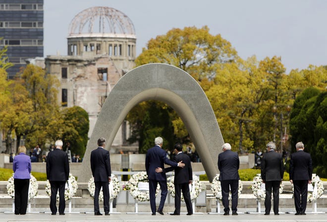 U.S. Secretary of State John Kerry, fourth from left, puts his arm around Japanese Foreign Minister Fumio Kishida after they and fellow G-7 foreign ministers laid wreaths at the cenotaph at Hiroshima Peace Memorial Park on April 11, 2016, in Hiroshima, western Japan. [Jonathan Ernst/The Associated Press]