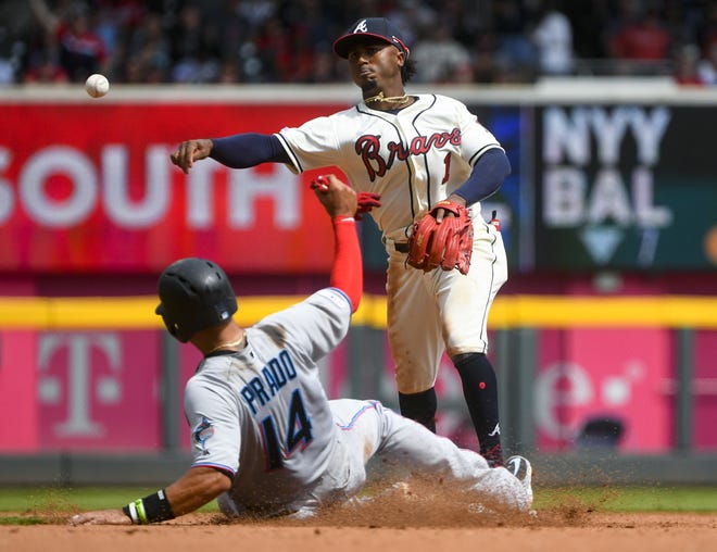 Atlanta Braves second baseman Ozzie Albies throws to first after forcing out the Miami Marlins' Martin Prado, and gets Starlin Castro at first base during the eighth inning of a game April 7 in Atlanta. [JOHN AMIS/THE ASSOCIATED PRESS