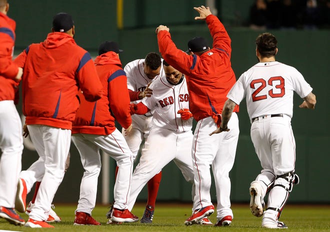 Boston Red Sox's Rafael Devers is congratulated by teammates after his walk-off single against the Toronto Blue Jays during a baseball game Thursday, April 11, 2019, at Fenway Park in Boston. Boston won 7-6. (AP Photo/Winslow Townson)