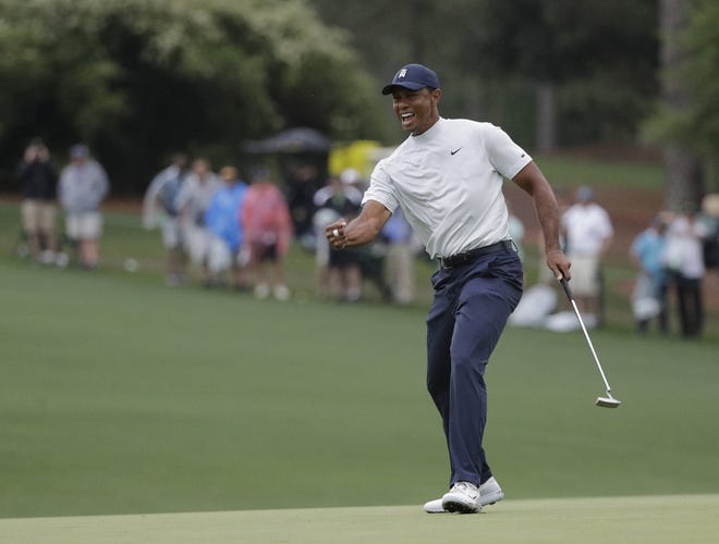 Tiger Woods reacts to his birdie putt on the 15th hole during the second round for the Masters golf tournament on Friday in Augusta, Ga. [DAVID J. PHILLIP/THE ASSOCIATED PRESS]