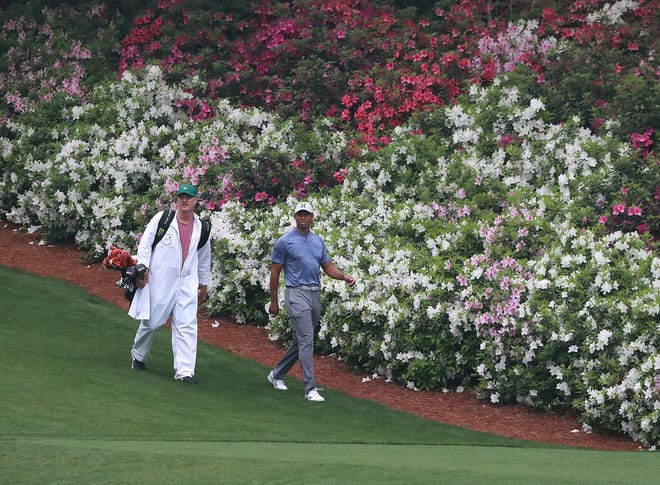 Tiger Woods and his caddie Joe LaCava walk down the 13th fairway during his practice round for the Masters at Augusta National Golf Club on Monday, April 8, 2019 in Augusta, Ga. [Curtis Compton/Atlanta Journal-Constitution/TNS]