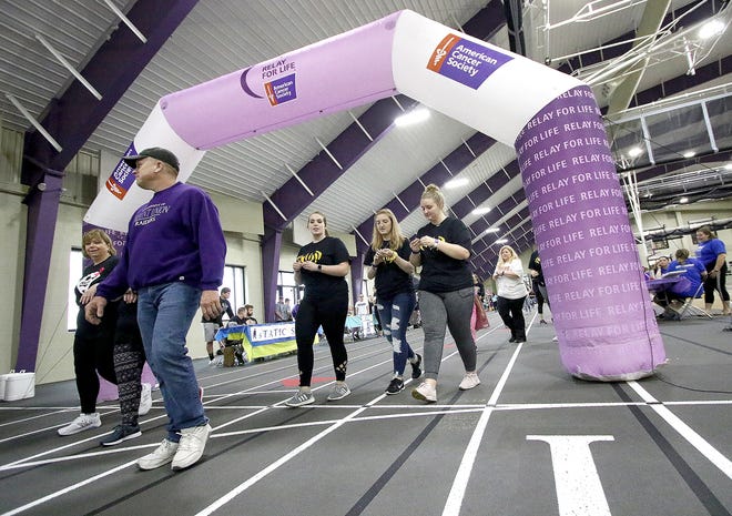 Cancer survivors, family and supporters walk around the track during the 2019 Relay for Life, held overnight Friday inside Peterson Field House at the University of Mount Union.