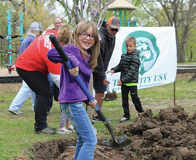 Quinn Holtzen, 7, plants a tree for Arbor Day at Johnstone Park in Bartlesville on Saturday. Roseanne McKee/Examiner-Enterprise