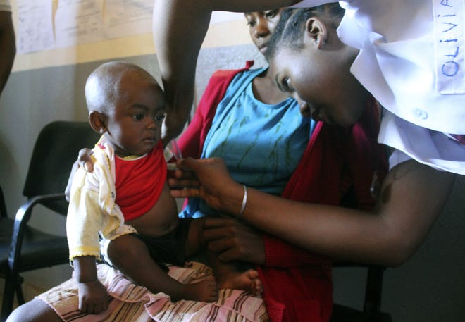 A volunteer nurse examines 6-moth-old Sarobidy, who is infected with measles, while her mother Nifaliana Razaijafisoa looks on, at a healthcare centre in Larintsena, Madagascar. As the island nation faces its largest measles outbreak in history and cases soar well beyond 115,000, the problem is not centered on whether to vaccinate children. Many parents would like to do so but face immense challenges including the lack of resources and information. [Laetitia Bezain/AP Photo]