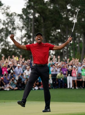 Tiger Woods lets loose with a yell after winning winning the Masters on Sunday for his 15th career major. [David J. Phillip/The Associated Press]