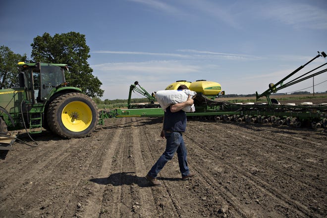 A farmer carries a bag of corn seed in Malden, Ill., on May 16, 2017. MUST CREDIT: Bloomberg photo by Daniel Acker.