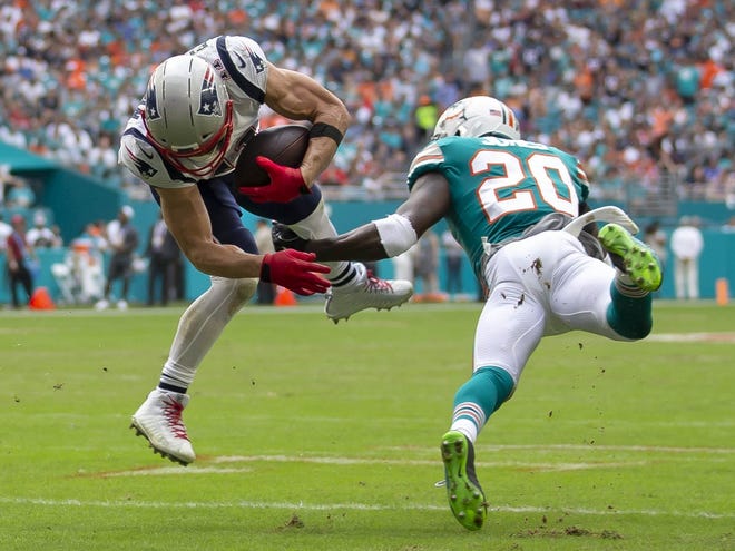 New England Patriots wide receiver Julian Edelman (11) is hit by Miami Dolphins free safety Reshad Jones (20) at Hard Rock Stadium in Miami Gardens, Florida on December 9, 2018. [ALLEN EYESTONE/palmbeachpost.com]
