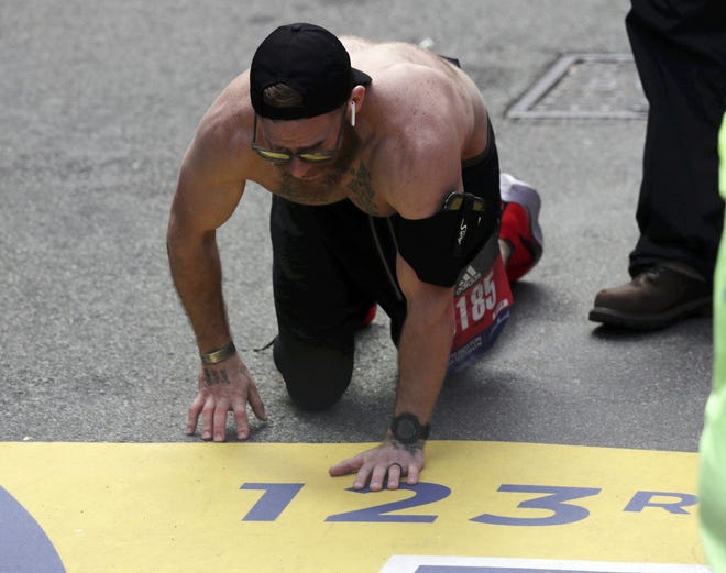Micah Herndon, of Tallmadge, Ohio, crawls to the finish line in the 123rd Boston Marathon on Monday, April 15, 2019, in Boston. (AP Photo/Charles Krupa)