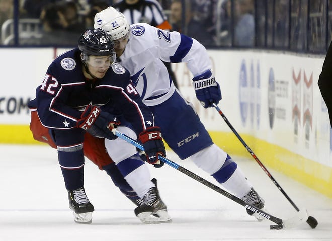 Columbus Blue Jackets' Alexandre Texier, left, of France, and Tampa Bay Lightning's Brayden Point chase a loose puck during the first period of Game 4 of the first-round playoff series,Tuesday in Columbus, Ohio. [JAY LaPRETE/THE ASSOCIATED PRESS]