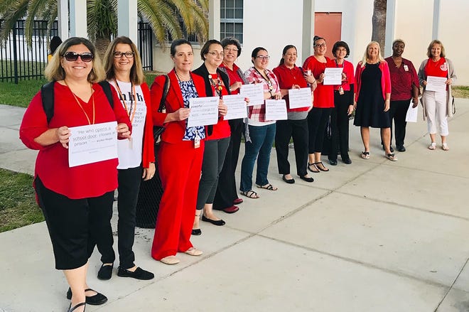 Leesburg High School teachers and staff dress in red and carry signs with inspirational quotes during the statewide walk-in for education funding on Wednesday. [Submitted / Lake County Education Association]