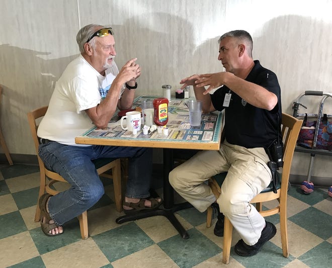 A resident chats with Community Services Officer Sam Kimmons during Coffee With a Cop at the Tropical Palm. [CONTRIBUTED PHOTO]