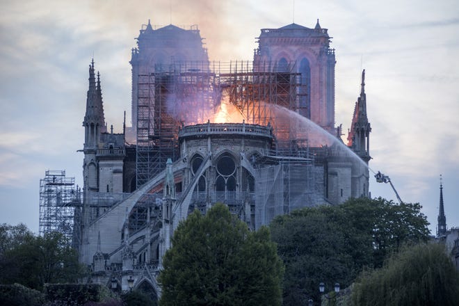 Flames and smoke rise Monday from a fire at Notre Dame Cathedral in Paris. [MARTIN BARZILAI/BLOOMBERG]