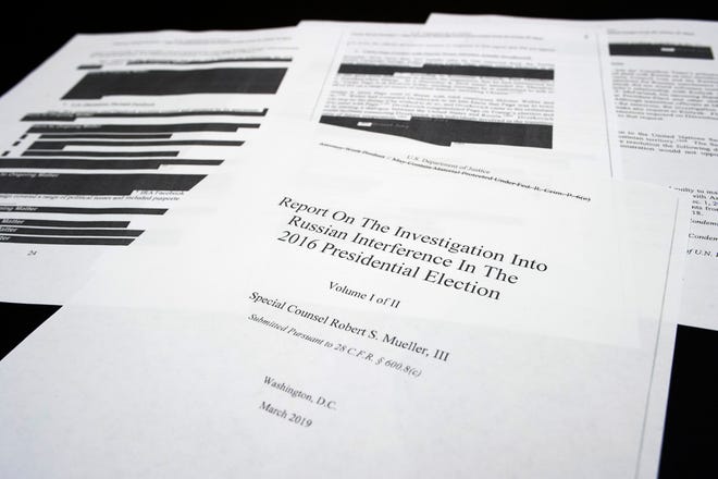 Four pages of the Mueller Report lay on a witness table in the House Intelligence Committee hearing room on Capitol Hill, in Washington, Thursday, April 18, 2019. (AP Photo/Cliff Owen)