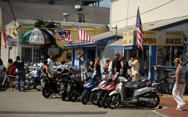 Mopeds are lined up for rent in Oak Bluffs in 2016. A crash that summer involving a moped rented from another business in town reignited debate on Martha's Vineyard about such rentals and has resulted in a lawsuit. [Merrily Cassidy/Cape Cod Times file]