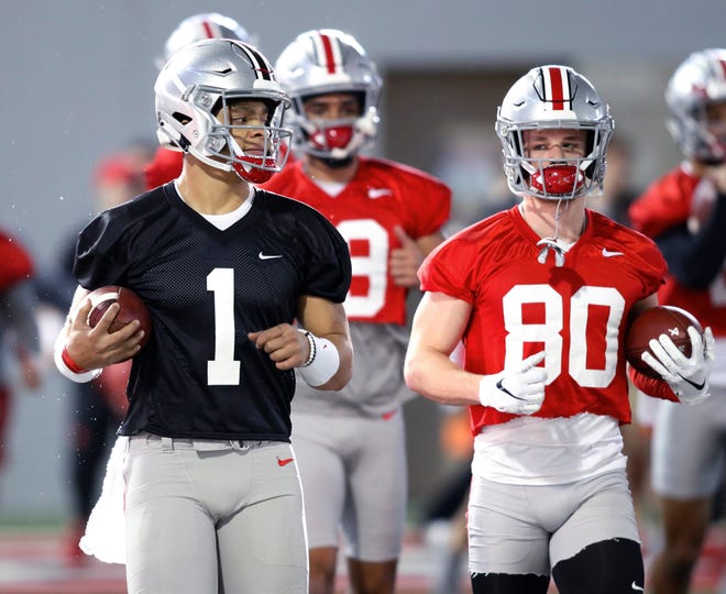 In this March 6, 2019, file photo, Ohio State quarterback Justin Fields, left, and wide receiver K.J. Hill run through a drill during the Buckeyes' practice in Columbus, Ohio. First-year coach Ryan Day i nsisted after the Buckeyes’ spring game last Saturday he hadn’t decided between Fields and redshirt freshman Matthew Baldwin, who spent much of last season rehabbing a knee injury. Baldwin announced he would transfer on Thursday, erasing any doubt that Fields, the biggest acquisition of the offseason, would be the starter. [Paul Vernon/The Associated Press]