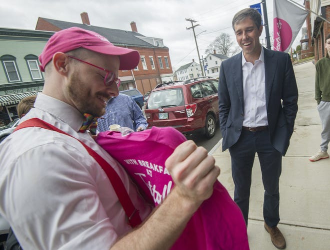 Emmett Soldati, owner of Teatotaller in Somersworth, welcomes presidential candidate Beto O'Rourke to his cafe with a T-shirt during a campaign visit Friday. [John Huff/Fosters.com]