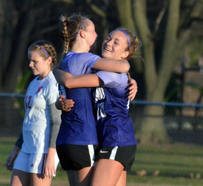 West Ottawa's Lucy Borski (right) is hugged by teammate Dani Kuiper after a goal against Holland in the Purple Power soccer game on Friday at West Ottawa. [Dan D'Addona/Sentinel staff]