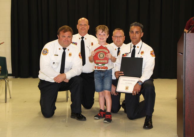 Carter Bascomb gets a special award for calling 911 when his mother needed help. Pictured, left to right, from Polk County Fire Rescue: Deputy Chief Colin Fredericks, Captain Glenn Anderson, Captain Eric Adams, Captain Andrew Gagliano. [PROVIDED BY POLK COUNTY FIRE RESCUE]