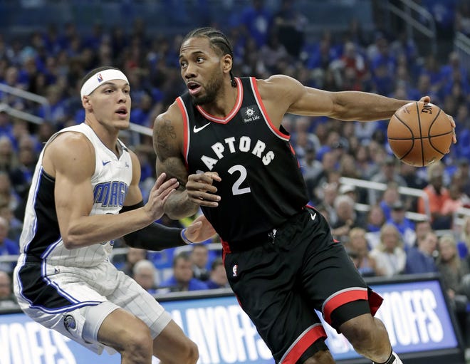 Toronto Raptors' Kawhi Leonard (2) drives to the basket against Orlando Magic's Aaron Gordon, left, during the first half in Game 4 of a first-round NBA basketball playoff series, Sunday, in Orlando. [John Raoux/AP Photo]