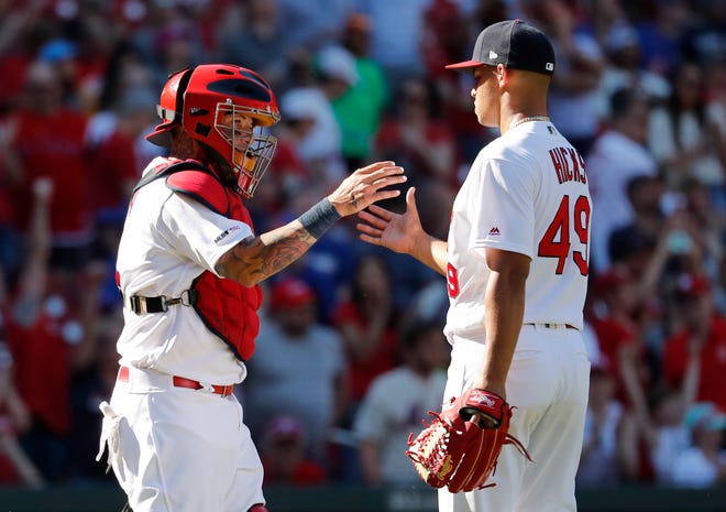 St. Louis Cardinals catcher Yadier Molina, left and relief pitcher Jordan Hicks celebrate following a 6-4 victory over the New York Mets in a baseball game Sunday, April 21, 2019, in St. Louis. (AP Photo/Jeff Roberson)
