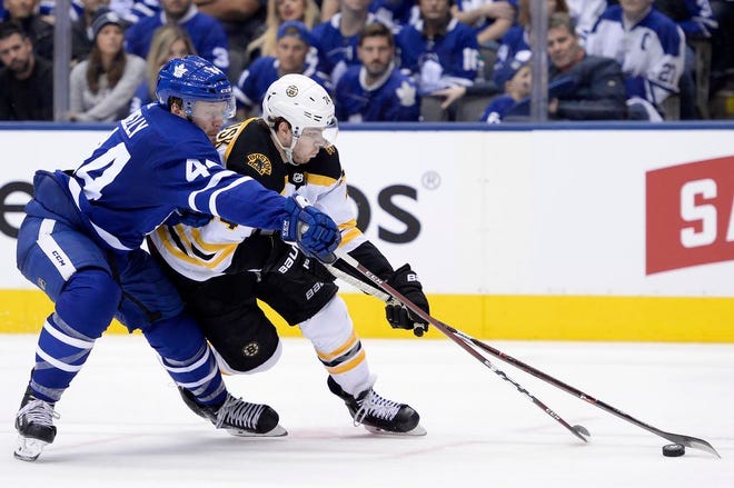 Toronto Maple Leafs defenseman Morgan Rielly (44) and Boston Bruins left wing Jake DeBrusk (74) battle for the puck during the third period of Game 6 of a first-round playoff series Sunday in Toronto.