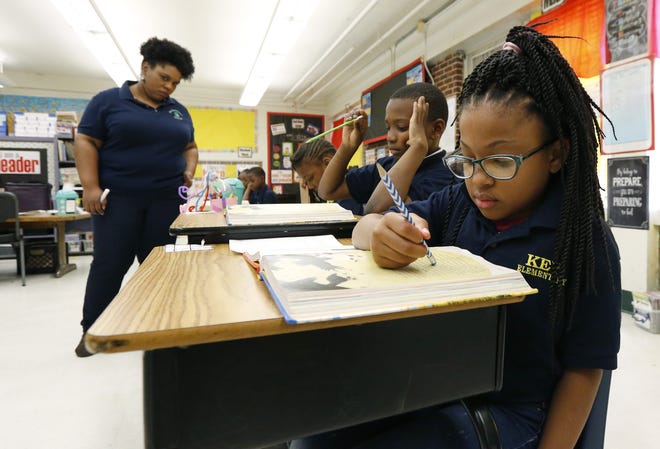 Elize'a Scott, a Key Elementary School third grade student, right, reads under the watchful eyes of teacher Crystal McKinnis, left, Thursday, April 18, 2019, in Jackson, Miss. (AP Photo/Rogelio V. Solis)