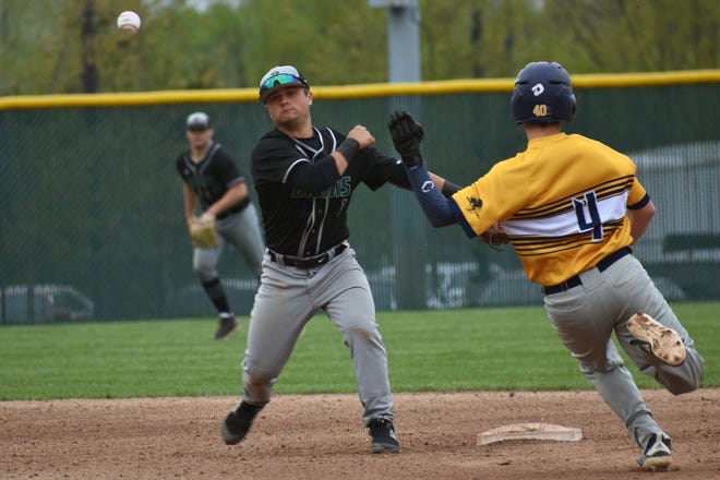 Rock Bridge second baseman Brett Mooney (3) throws the ball to first base for a double play while Battle's Aaron Scofield (4) slides into second base during the first inning of a baseball game Tuesday night at Rock Bridge High School. [Eric Blum/Tribune]