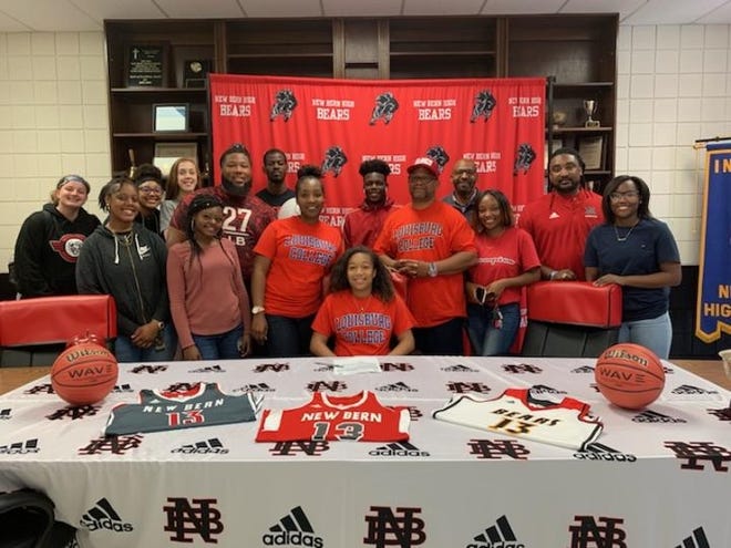 New Bern basketball player Jordan Reddick (seated, middle) signs her National Letter of Intent to play collegiately at Louisburg. Reddick is joined by family and friends. [CONTRIBUTED PHOTO]