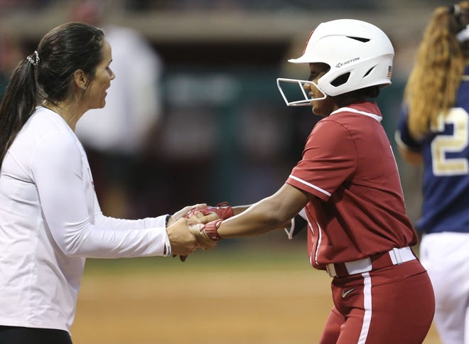 Assistant head coach Alyson Habetz greets Elissa Brown as she arrives safely at first during the Crimson Tide's game with Georgia Tech Wednesday, March 27, 2019. Alabama defeated Belmont 6-4 on Tuesday. [Staff File Photo/Gary Cosby Jr.]