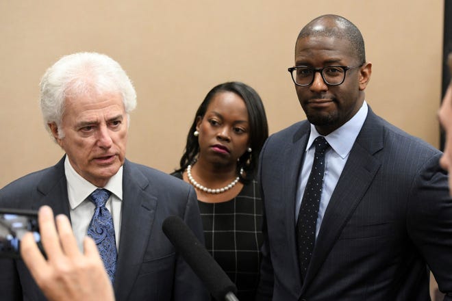Former Mayor of Tallahassee Andrew Gillum, right, and his wife, R. Jai Gillum, center, listen as Gillum's attorney Barry Richard addresses the media after it was announced that Gillum settled with the Florida Commission on Ethics Wednesday, April 24, 2019. Gillum settled with the Florida Commission on Ethics and agreed to pay a $5,000 fine to settle an ethics complaint that he violated civil law by accepting a gift from a lobbyist. The state Ethics Commission agreed to drop four additional counts of violations. [Alicia Devine/Tallahassee Democrat via AP]