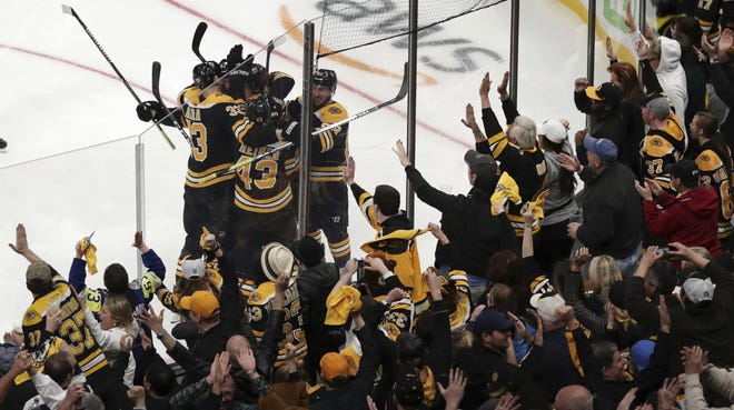 Bruins fans celebrate after a goal by Bruins center Sean Kuraly (middle of pile) against the Toronto Maple Leafs during the third period of Game 7 on Tuesday. [AP Photo/Charles Krupa]