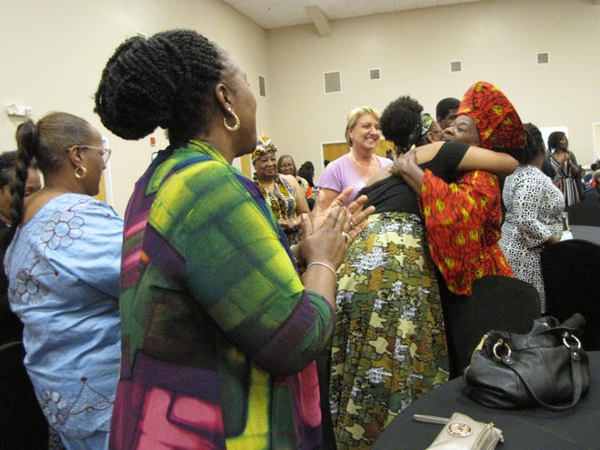 LaVern Porter, right, is greeted with a standing ovation and hugs at the“Celebration of LaVern’s Birthday and 51 Years Of Teaching” event held Saturday at Springhill Baptist Church. [PHOTOS BY AIDA MALLARD/SPECIAL TO THE GUARDIAN]