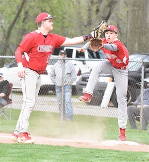 Cameron Woods (left) and Brady Russell both try to make a play at first during a league contest against Strasburg.